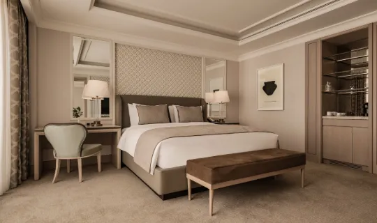 King-size luxury bed and and work desk in the Deluxe Adapted Room at Giza Palace