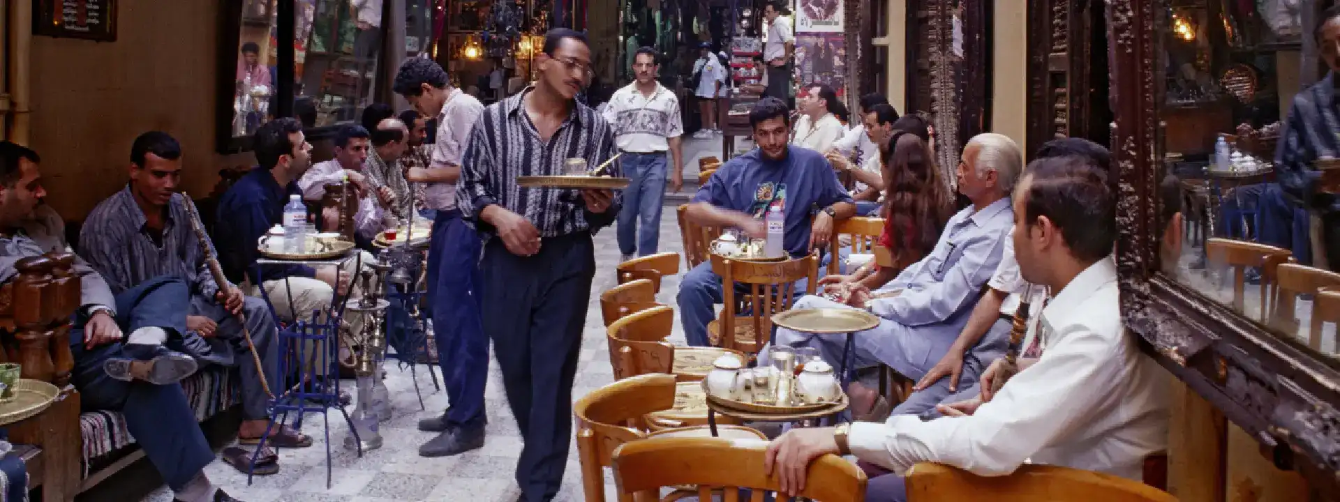 مقهى صاخب في القاهرة يزخر بالأشخاص الذين يستمتعون بالشاي والقهوة والشيشة